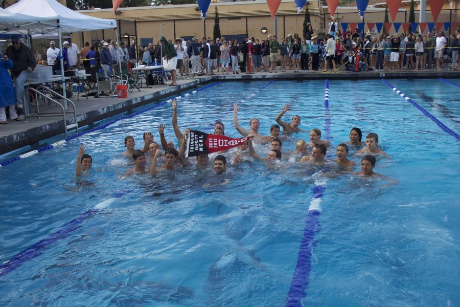 Boys+swimming+coach+Dave+Beutel+joins+the+swimmers+in+the+pool+to+celebrate+their+win.+Photo+by+Kristie+Lee