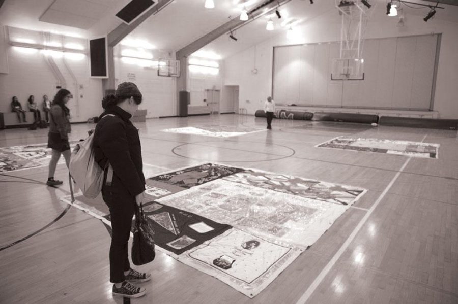 SOLEMN VISITATION:  Students observe pieces of the AIDS quilt on World AIDS Day on December 1. Portions of the 54-ton quilt were displayed in Ruby Scott Gym during tutorial.    Photo by: Joel Abrahams