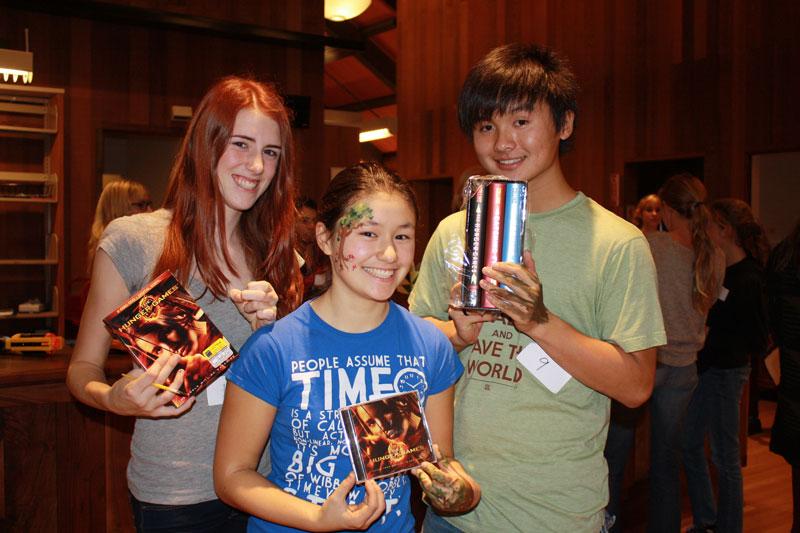Junirs Cate Wilmoth, Grace Lightner, and Josh Leung display their prizes following the Hunger Games event.