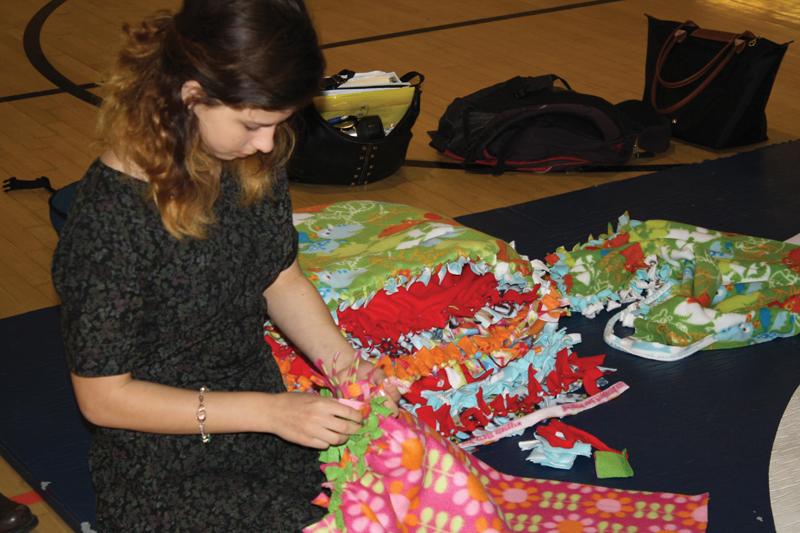 BUNDLE UP:  Sophomore Starr Ingram was one of many gathered in Ruby Scott Gym to craft no-sew blankets for Project Night Night.  		      
 Photo by Emma Boczek
