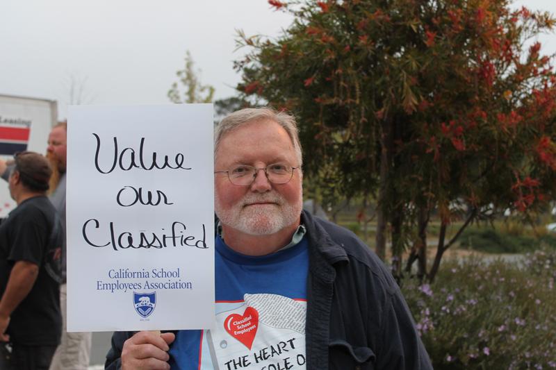  Lead Custodian Patrick Gannon held a sign on March 27 outside Tam. 