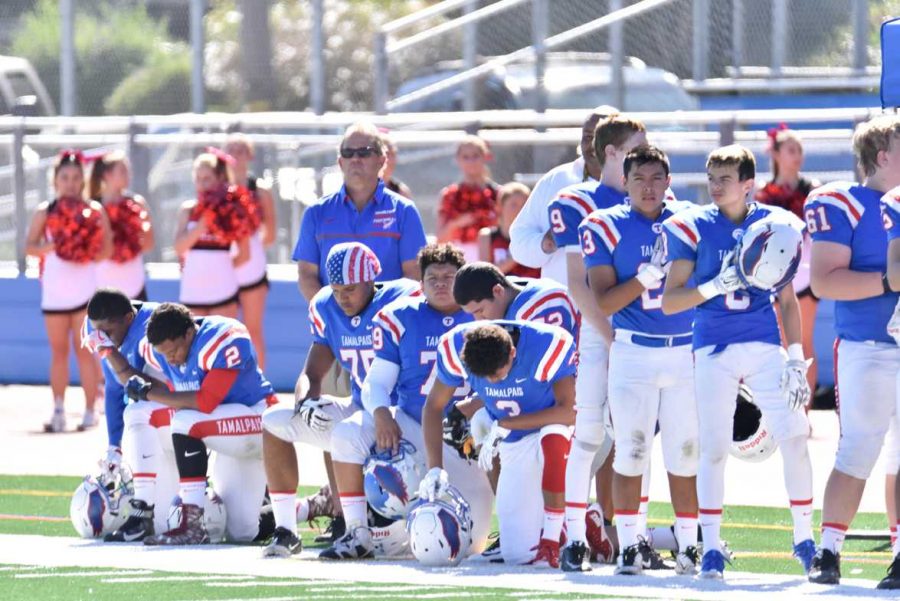 Varsity football players (left to right) seniors Tre’Chaun Berkley and Leonjae Silas, juniors Tristan Mitchell, Pedro Mira, and Oscar Corona, and senior Jordan Smith take a knee during the national anthem before the homecoming game against Redwood on October 8.														             		         PHOTO COURTESY OF HONG SOON PARK