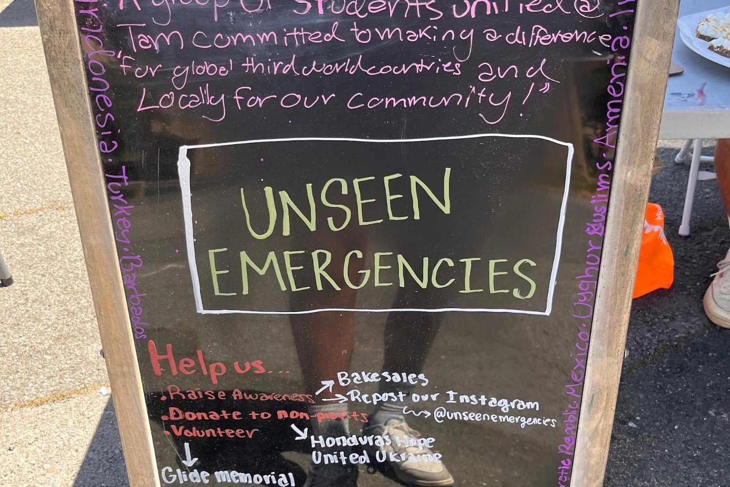 Unseen Emergencies, a club at Tamalpais High School that spreads awareness of global political issues, set up a booth and sign at Diversity Day.