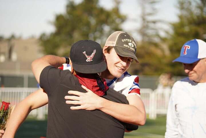 Coach Mejia hugs a player.